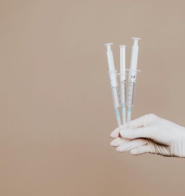 Syringes on a beige background, symbolizing men's weight loss injection treatments